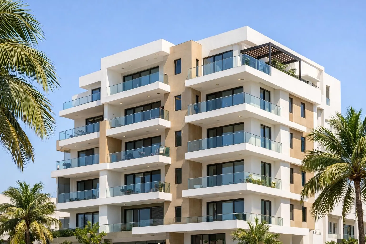 Immeuble résidentiel moderne aux façades blanches et beiges, avec balcons vitrés, entouré de palmiers