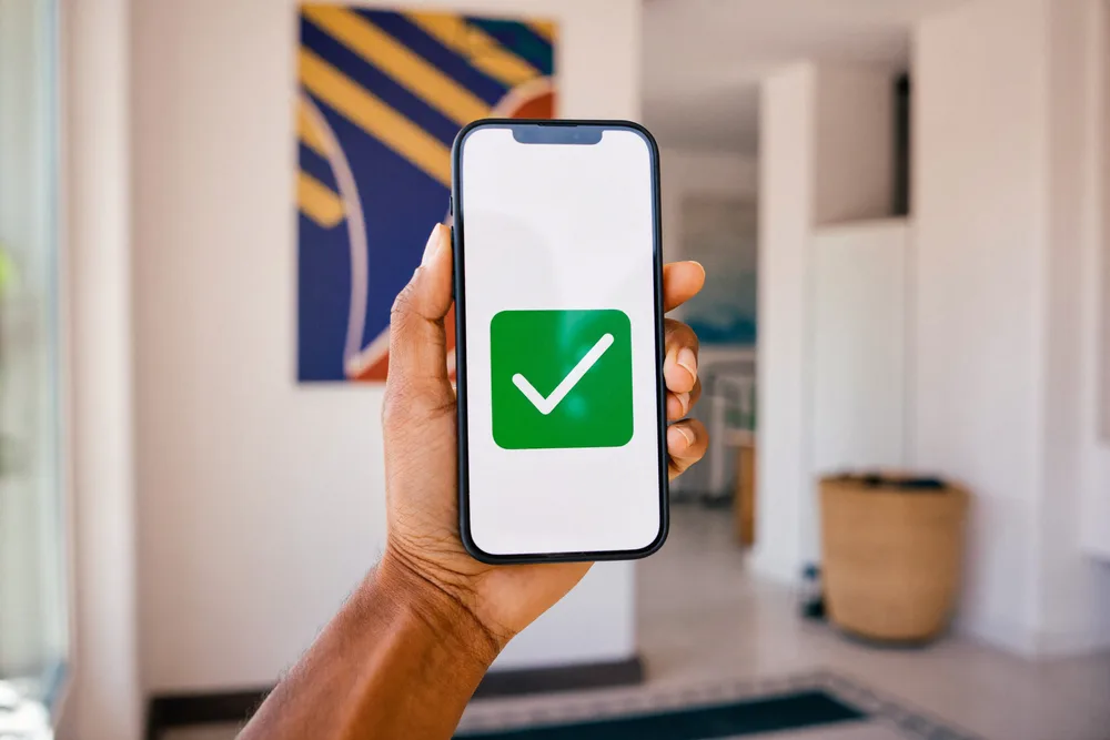 Illustration : une main tient un téléphone qui affiche une coche verte de paiement reçu