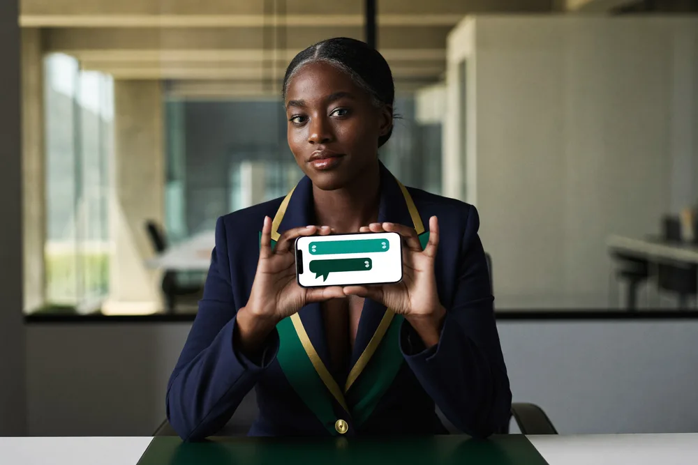 Illustration : une gérante tient un téléphone qui affiche une conversation de relance